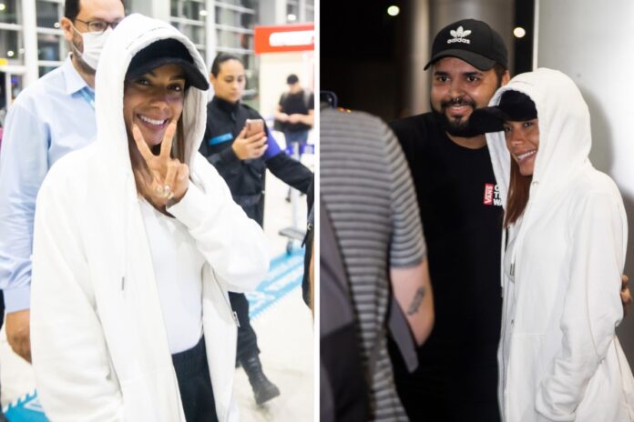 Anitta com fã em aeroporto