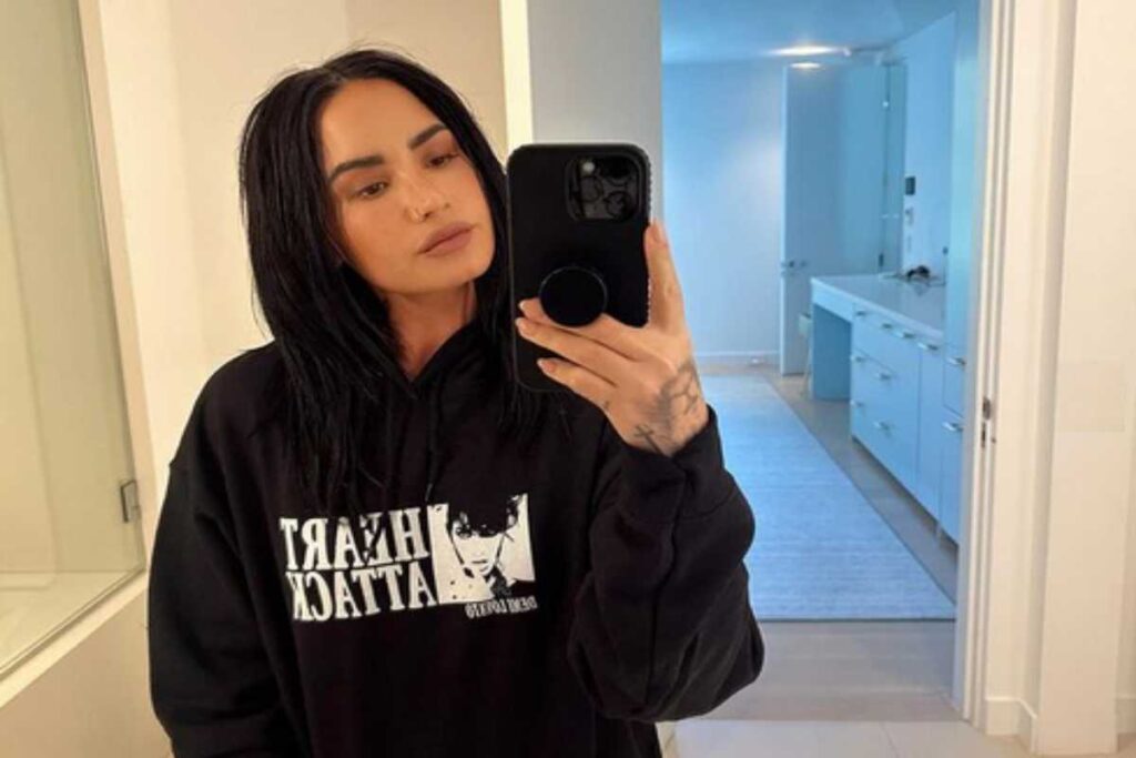 Demi Lovato de moletom preto na frente do espelho