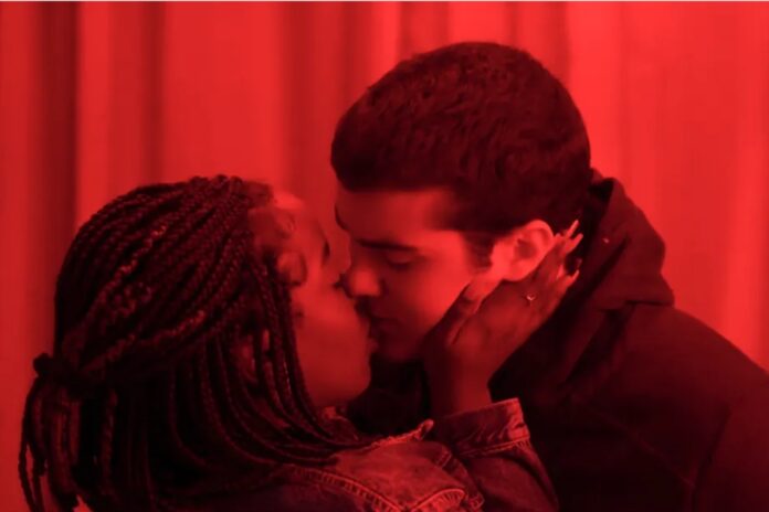 kate (clara moneke) e rafa (caio manhente) se beijando em vai na fé